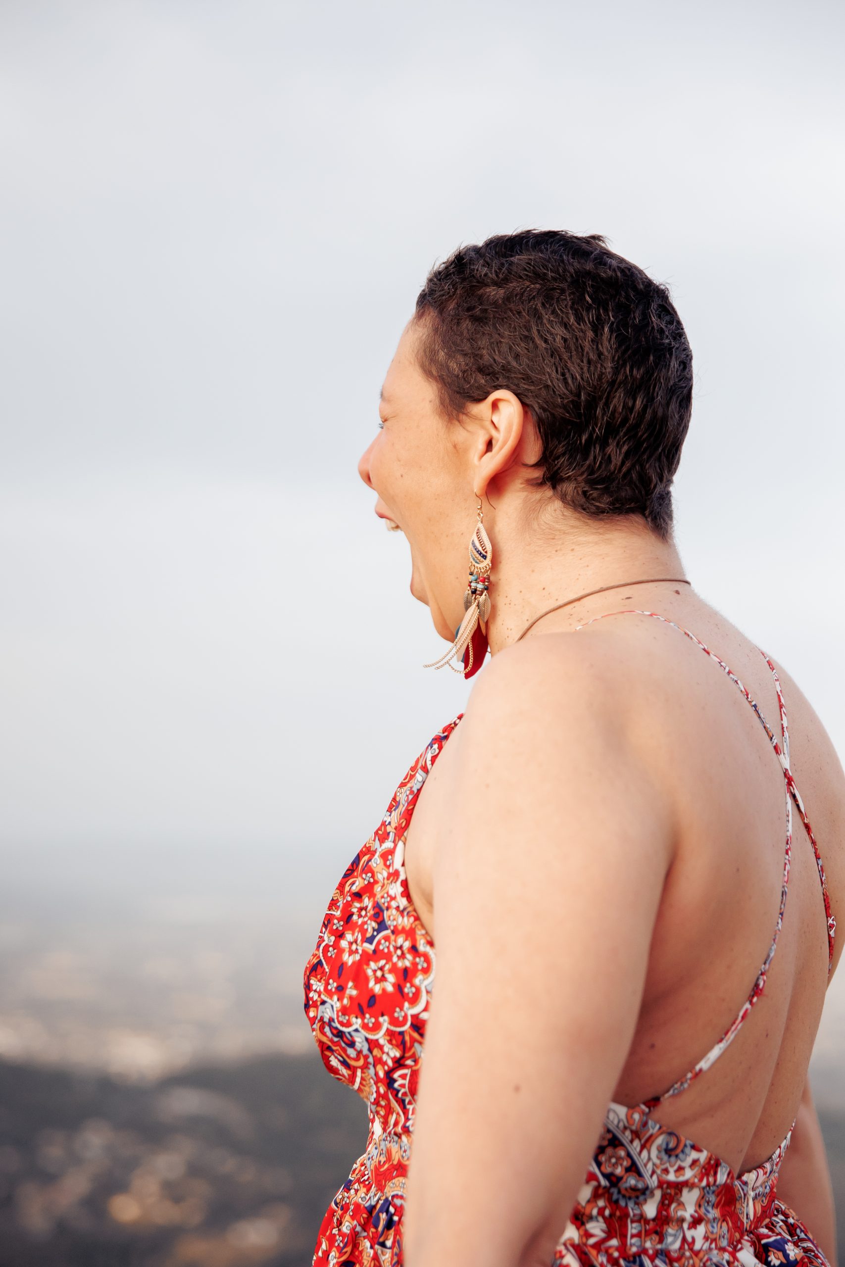 Femme en robe fleurie, de profil, à la colline